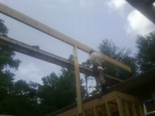 Carpenter setting a ridge beam over a new addition frame — Ice Dam Removal by Roofing Brothers in Broken Arrow
