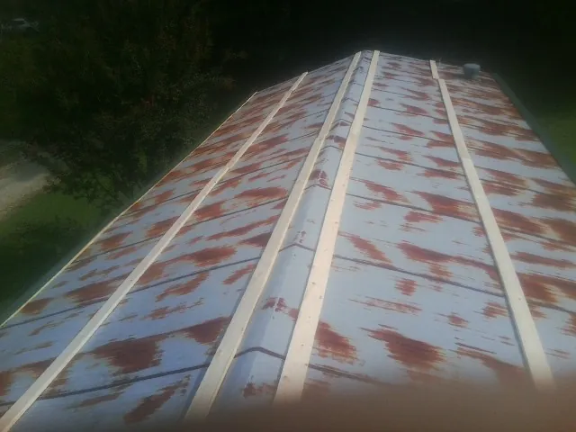 Rusted metal roof panels with new wood purlins before replacement — Storm Damage Roof Repair in Broken Arrow by Roofing Brothers