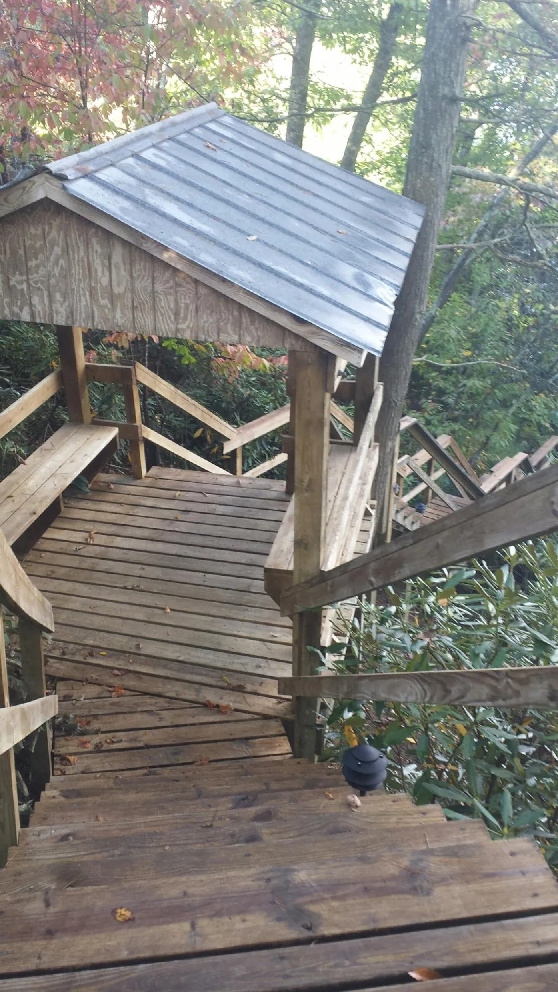 Metal roofed shelter over wooden steps on a wooded walkway — Skylight Repair & Installation work by our crew in Broken Arrow