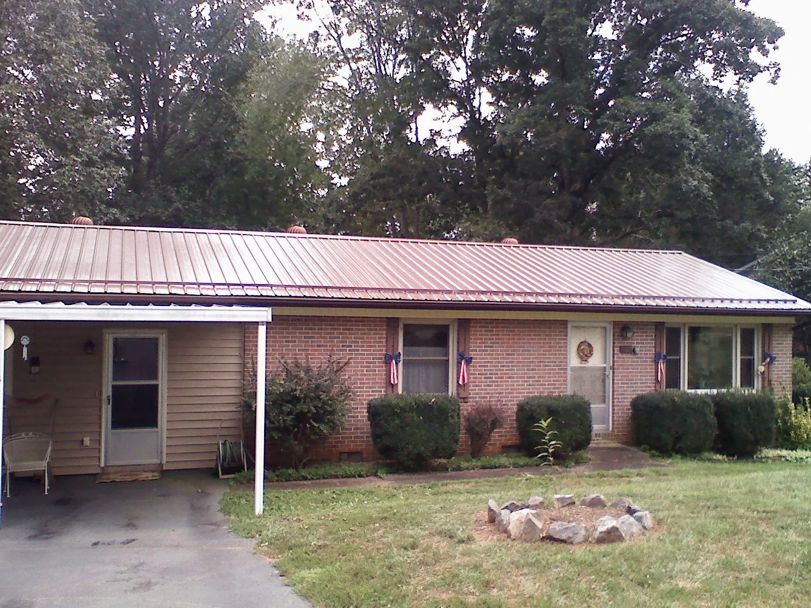 Bronze metal roof and carport on a brick ranch home — Roof Repair work by our crew in Broken Arrow