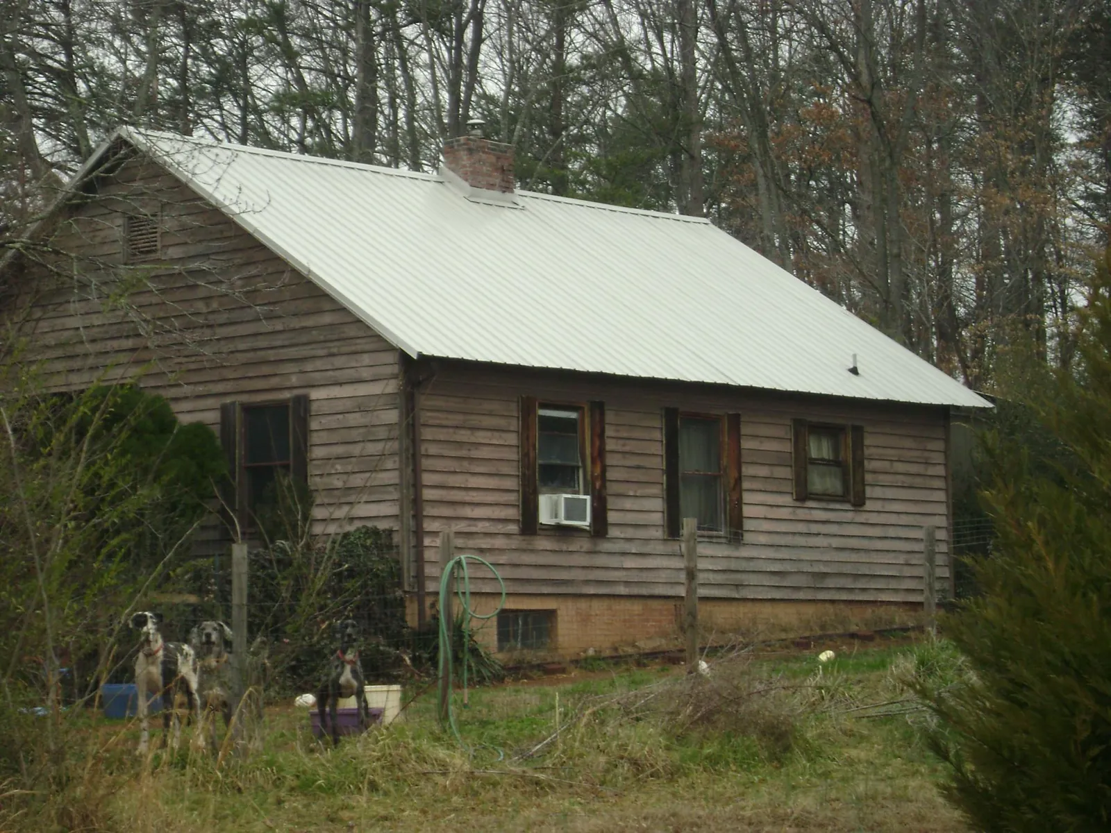 White metal roof on an old wood sided farmhouse, from a Asphalt Shingle Roof Repair job in Broken Arrow